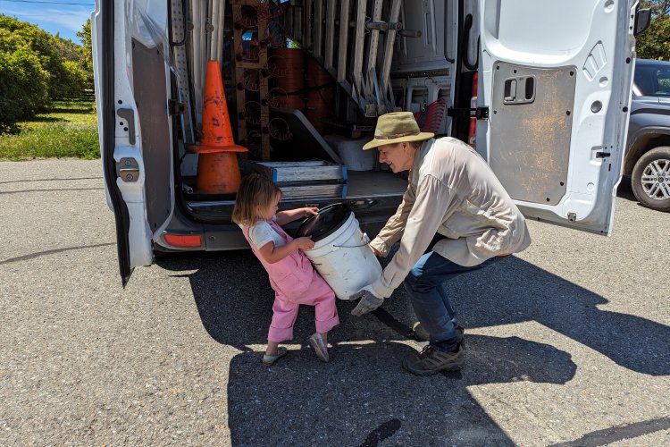 One of the youngest members of the farm family helps Craig pack up the buckets at the end of the harvest